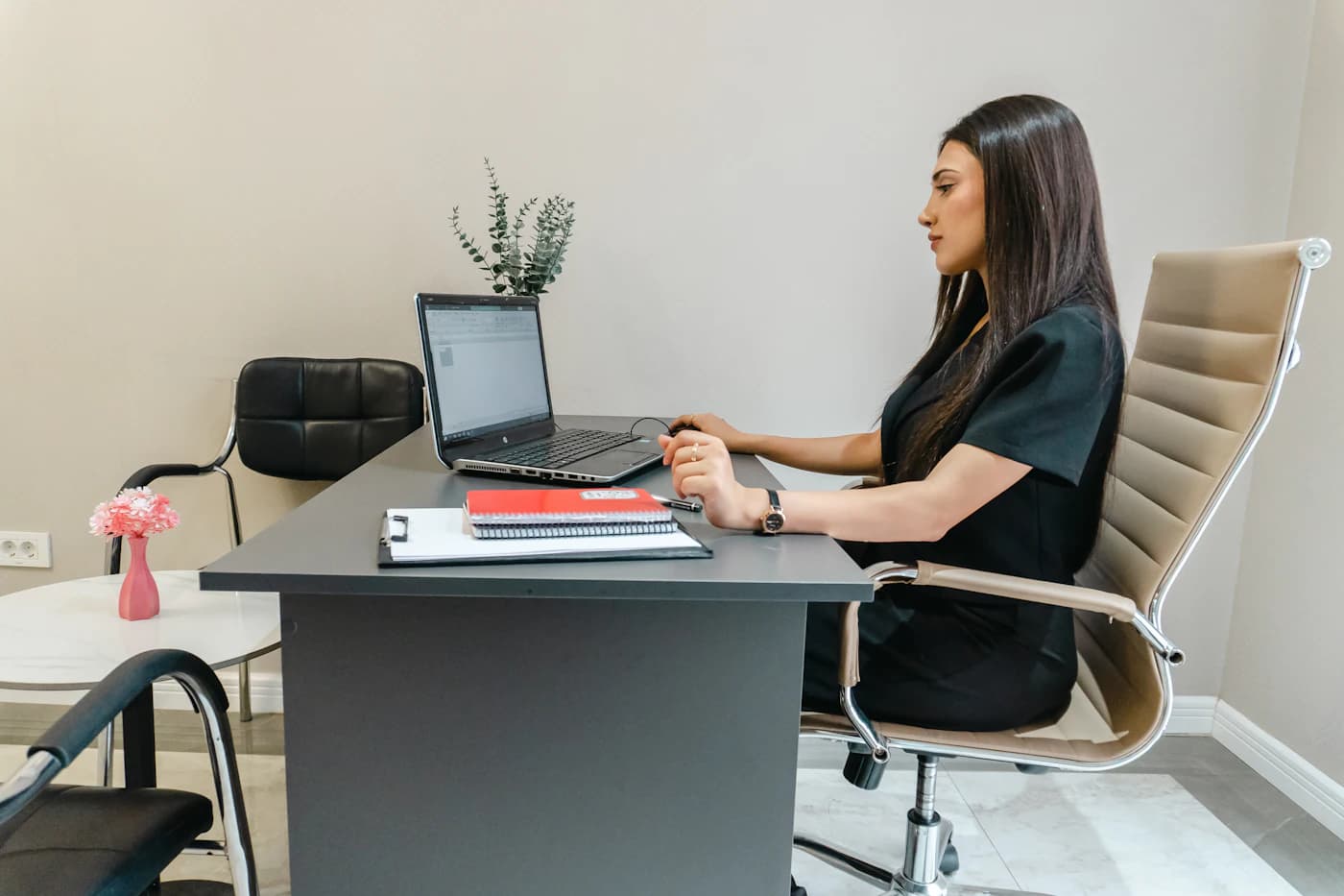 An adviser working at a laptop in a bright office